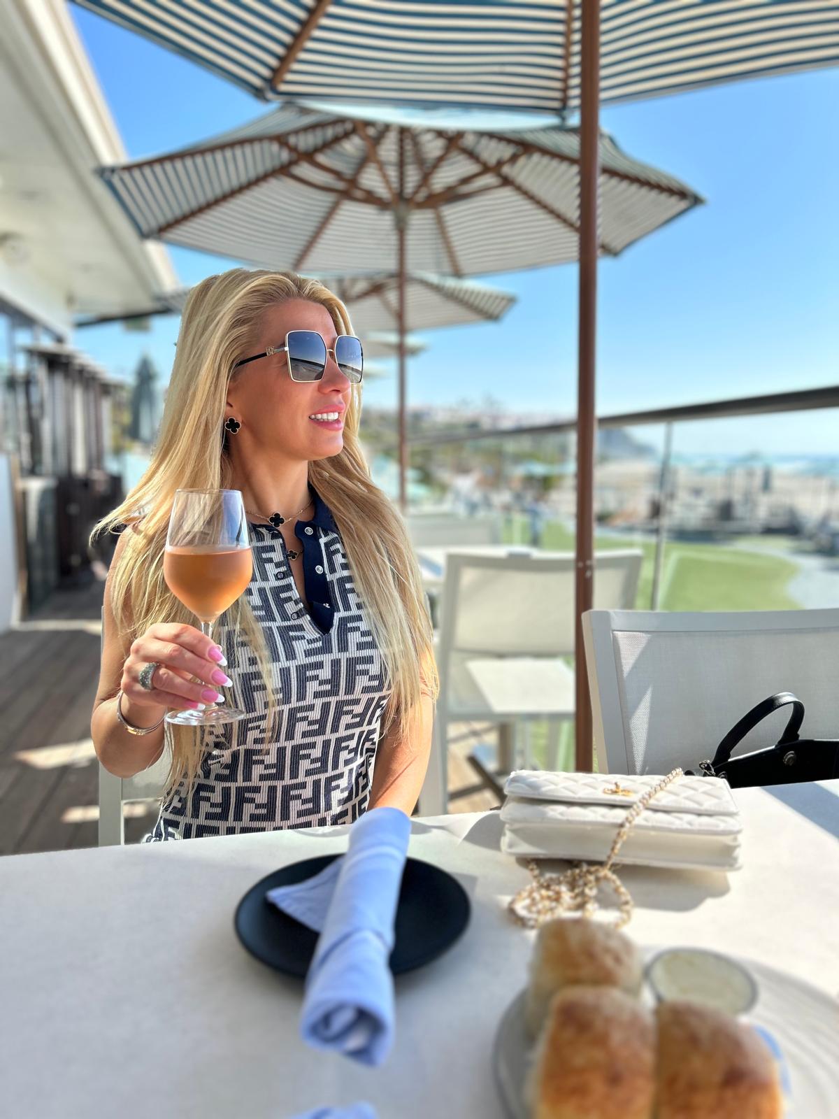 Tanja seated outdoors with a glass