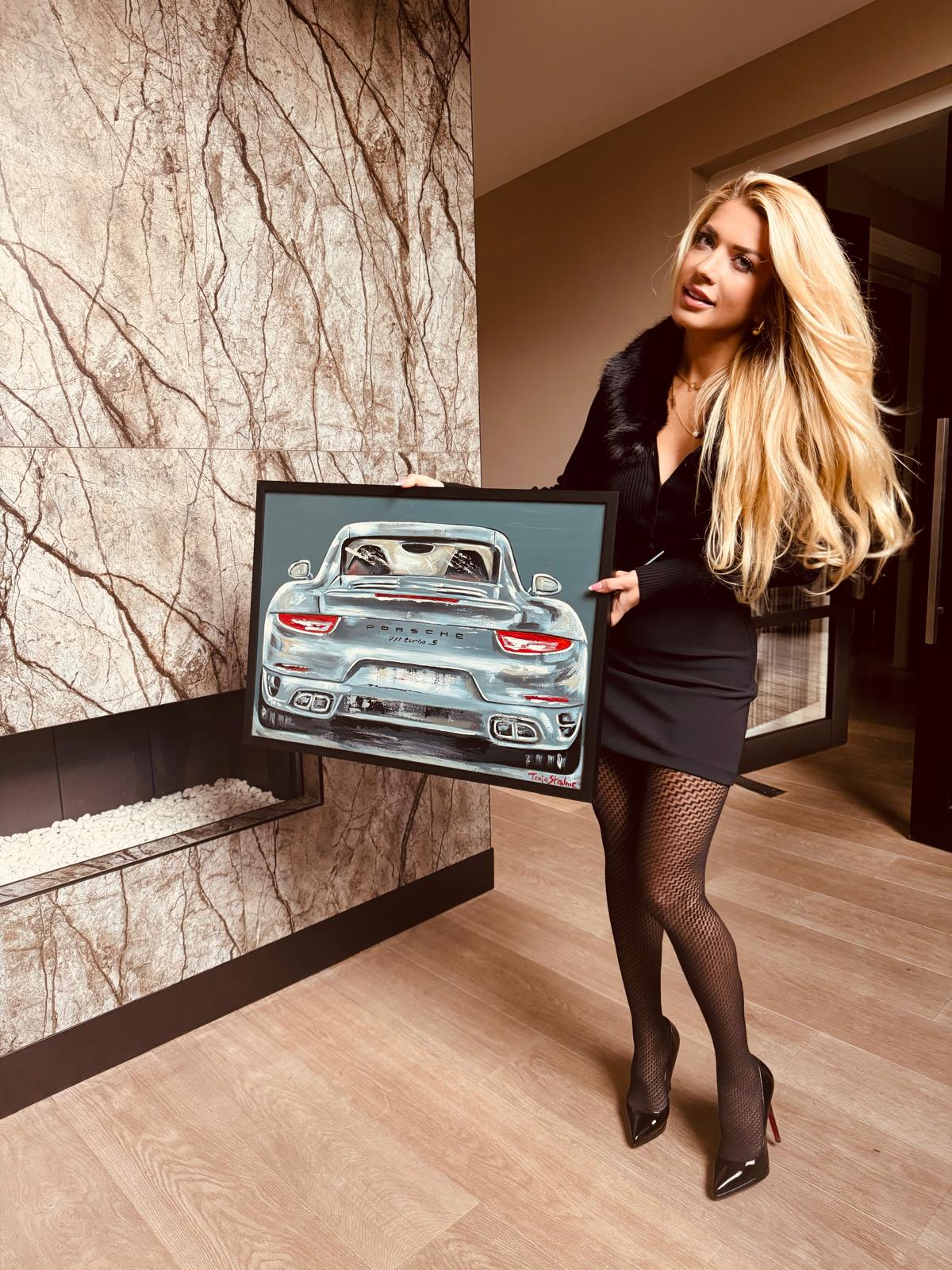 Tanja holding a framed Porsche painting