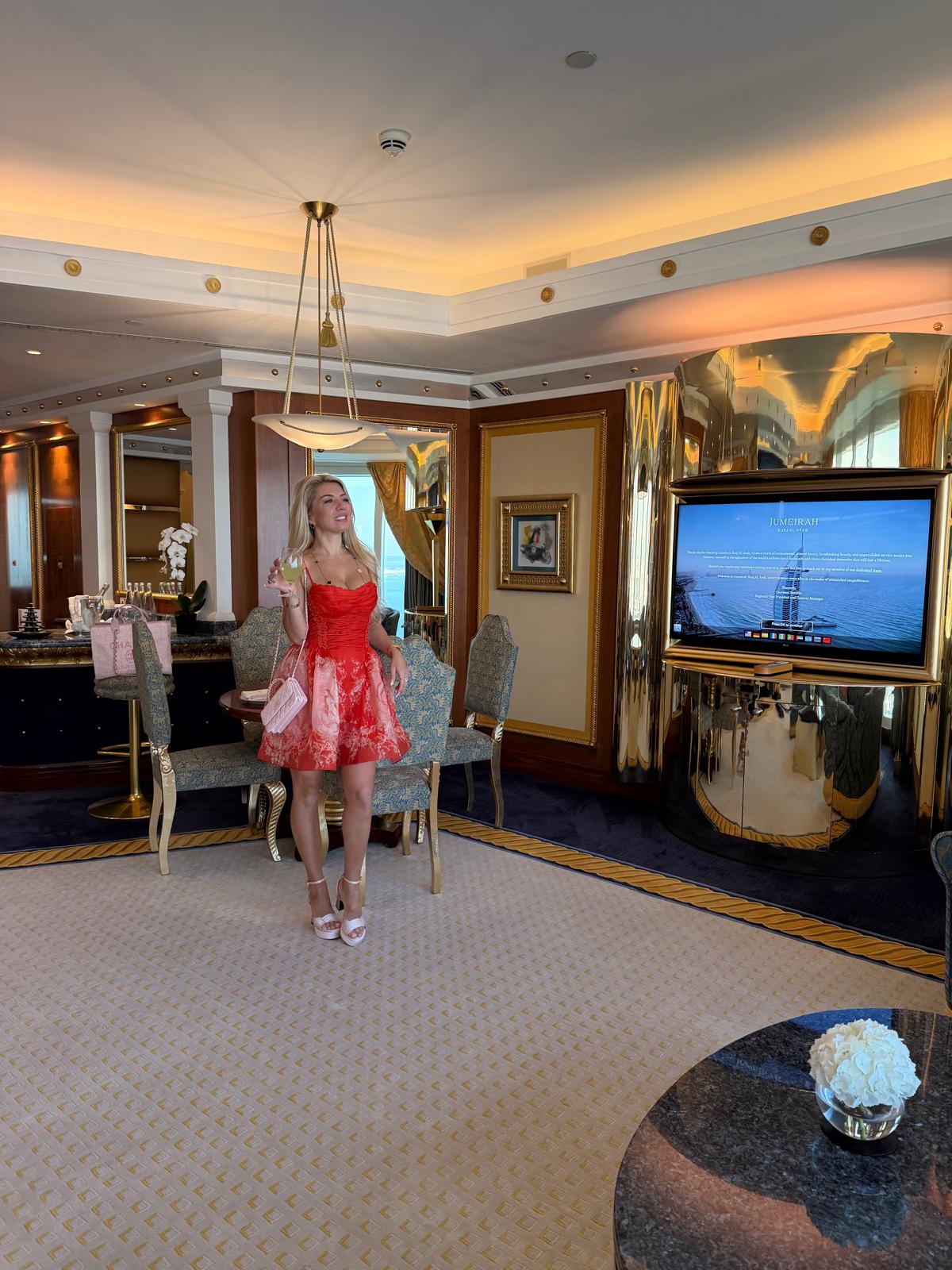 Tanja standing in a room in a red dress